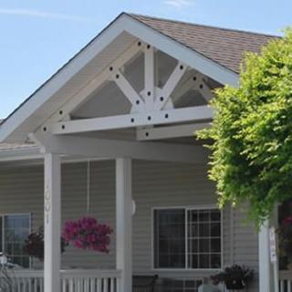 Front view of a house with a white gable roof and porch.