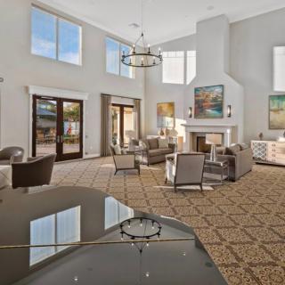 A spacious and modern living room with elegant furniture, a fireplace, and a grand piano.