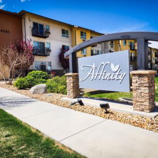 An apartment complex with a prominent entrance sign and well-maintained landscaping.