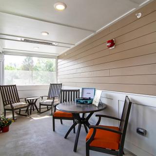 A cozy indoor patio with comfortable seating and a table, ideal for relaxing or working.