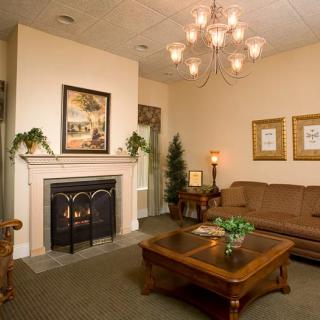 A cozy living room featuring a fireplace, elegant chandelier, and comfortable seating arrangement.