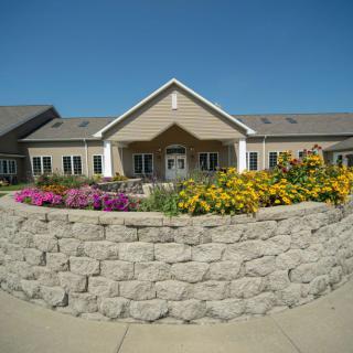 A well-maintained building with a landscaped front entrance adorned with colorful flowers.