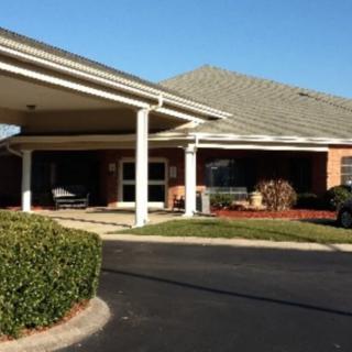 A building with a covered entrance and landscaped surroundings.