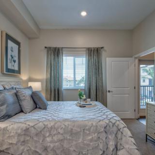 A cozy bedroom with elegant decor, featuring a neatly made bed, stylish curtains, and soft lighting.