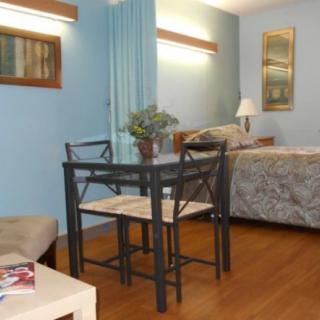 A cozy apartment interior with a small dining table and bedroom area.