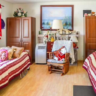 A cozy bedroom with twin beds, decorated with red-striped bedding and various furnishings.