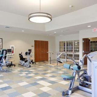 A spacious fitness area equipped with various exercise machines, designed for rehabilitation and general health.
