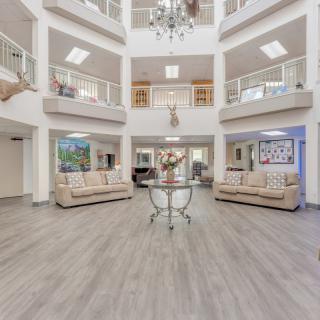 A spacious and modern lobby featuring elegant sofas and a chandelier.