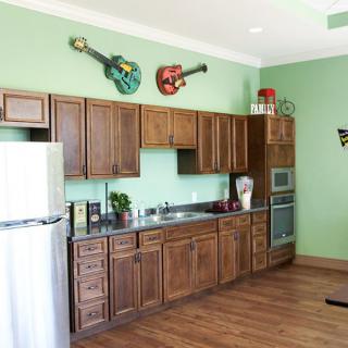 A kitchen with wooden cabinets and guitars as wall decor.