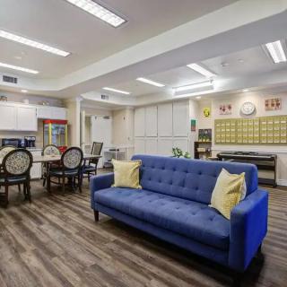 A modern and cozy living space with a blue sofa and dining area.
