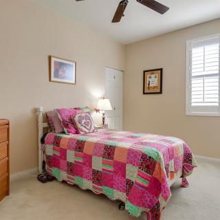 A cozy bedroom with a colorful quilt on the single bed and warm decor.
