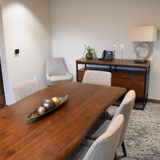 A modern dining room featuring a wooden table, stylish chairs, and elegant decor.