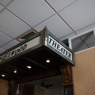 A vintage theater marquee sign hanging indoors.