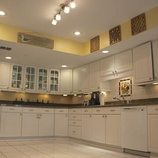 A modern kitchen with white cabinets and tiled flooring.