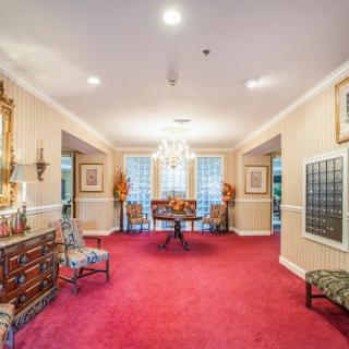 An elegant lobby featuring luxurious furnishings and a vibrant red carpet.