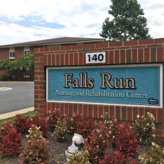 Sign for Falls Run Rehabilitation Center surrounded by floral landscaping.