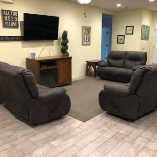 A cozy living room with modern gray sofas, a flat-screen TV, and stylish decor.