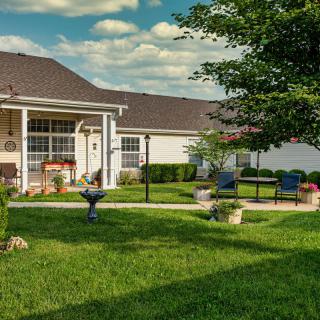 A cozy backyard with a patio, seating area, and well-maintained lawn.