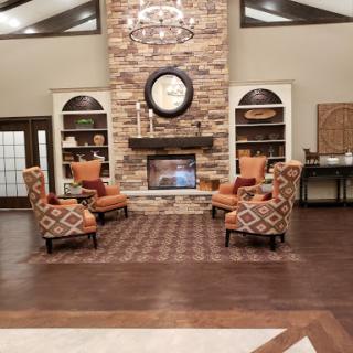 A cozy living room featuring a stone fireplace and stylish seating arrangements.