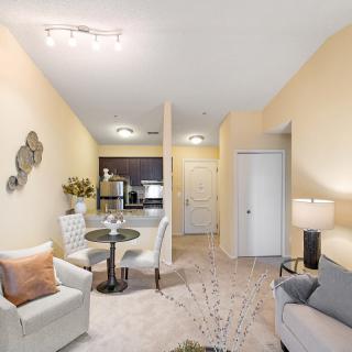 A modern apartment interior featuring a cozy living room and dining area connected to the kitchen.