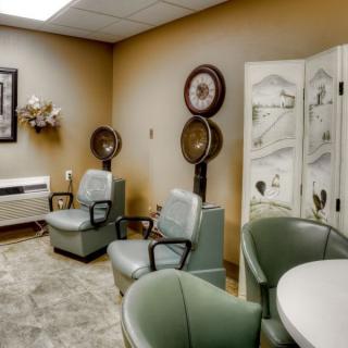 A cozy salon interior with vintage-style chairs and hair dryers.