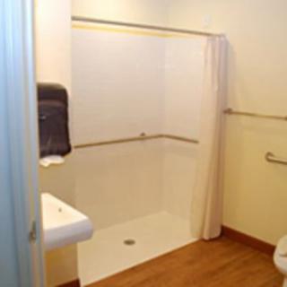 An accessible bathroom with a walk-in shower and safety features.