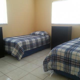 A simple bedroom featuring two twin beds with checkered bedding.