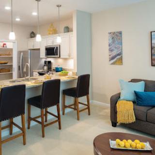 A stylish open-concept kitchen and living room featuring modern appliances and comfortable seating.