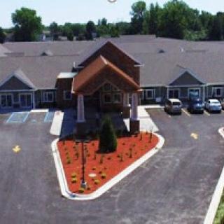 A welcoming view of a residential building with landscaped gardens and parking.