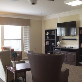 A cozy and modern living room with a television, bookshelf, and comfortable seating.