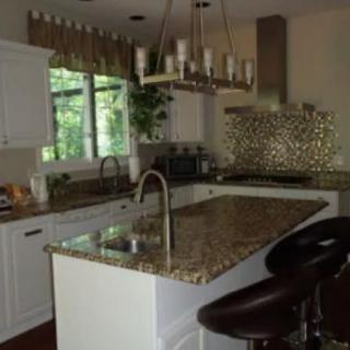 Modern kitchen with a central island and elegant granite countertops.