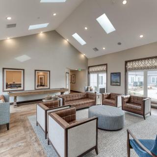 A spacious and modern living room with ample seating, skylights, and large windows.