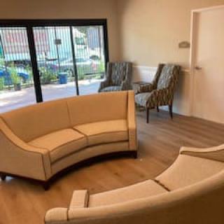 A cozy living room setting with curved sofas and large windows.