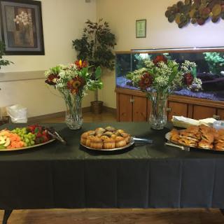 A beautifully arranged buffet featuring fresh salads and a selection of pastries, complemented by floral decorations.