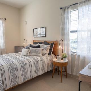 A cozy bedroom with a neatly made bed, soft lighting, and elegant decor.