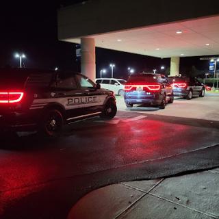Police vehicles parked at a facility during nighttime.