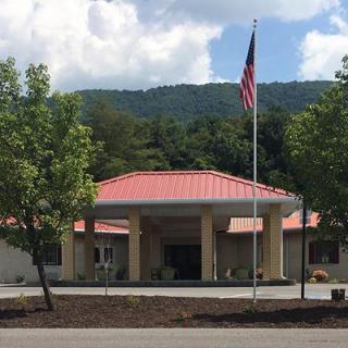 A building with a red roof and an American flag, set against a mountainous backdrop.