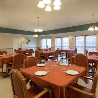 A spacious dining room setup with neatly arranged tables and chairs, ready for a meal.