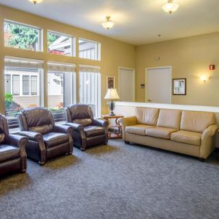 A cozy living room with comfortable seating, large windows, and warm lighting.