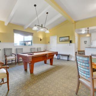 A well-lit game room featuring a pool table and various seating options.