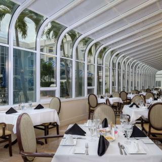 Elegant restaurant with large glass windows and neatly set tables.