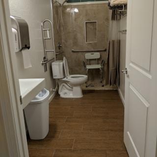 A modern bathroom featuring essential facilities including a toilet, sink, and a shower area.