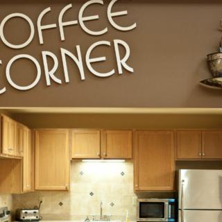 A cozy kitchen area labeled 'Coffee Corner' with wooden cabinets and modern appliances.
