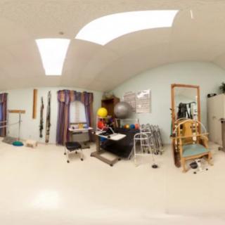 A spacious exercise room filled with various fitness equipment and therapy balls.