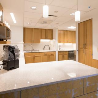 A modern kitchen with sleek countertops, wooden cabinets, and stylish lighting.