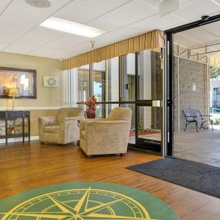 A cozy lobby area with comfortable chairs and large glass doors inviting natural light.