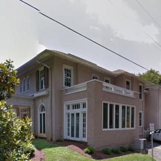 A modern two-story residential house with large windows.