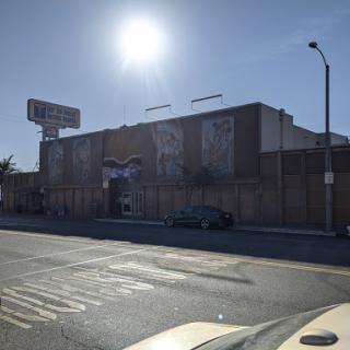 A commercial building in an urban setting captured under bright sunlight.