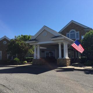 A building entrance with American flags under a clear blue sky.
