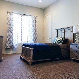 A cozy bedroom with a single bed and elegant furnishings.